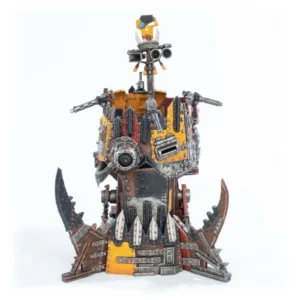 Steampunk robot sculpture made from scrap metal with yellow/orange panels on a jagged, spiked base.